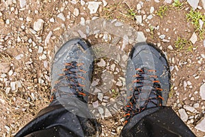 Foam from the water coming out of wet approach shoes on the legs of the tourist after intensive trekking on the trail