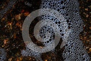 Foam on the water. Dark water