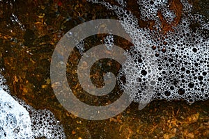 Foam on the water. Dark water