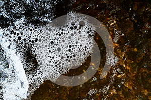 Foam on the water. Dark water