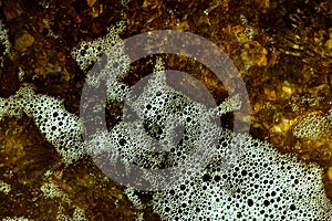 Foam on the water. Dark water