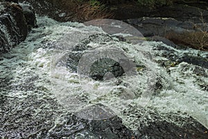 Foam and water running fast through rocks