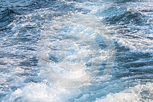 Foam wave trail behind ship, textured white water surface