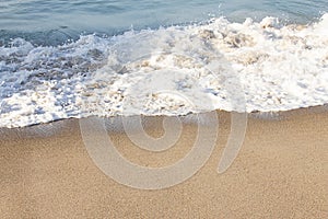 Foaming breaking wave and backwash foam on a sandy shoreline