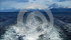 Foaming water at the stern of cruise ship with les eclaireurs lighthouse in the distance, Beagle channel, Ushuaia