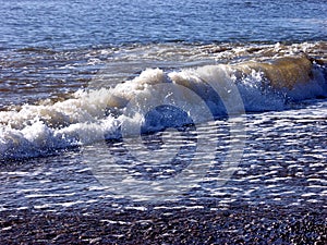 Foaming waves breaking on a pebble beach