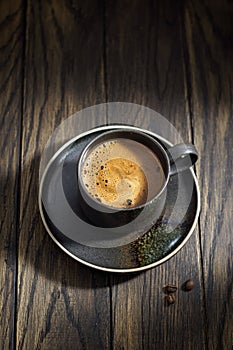 Foamy black coffee cup on rustic table