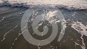 Foamy ocean waves washing sand. Waves hitting beach