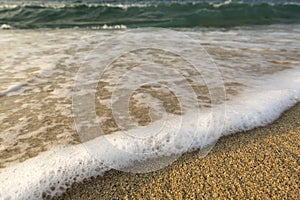 Foamy soft wave on sand beach