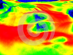 Foamy water level of waterfall, curves between boulders of rapids. Water of mountain river in infrared photo. Amazing thermography