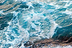 Foamy water waves at the ocean, view from above.