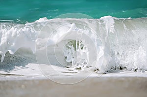 Foamy wave of blue ocean. Beach and tropical sea white foam.