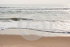 Foamy waves on calm beach