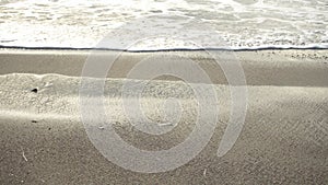 Foamy Waves Gently Lapping Sandy Beach.