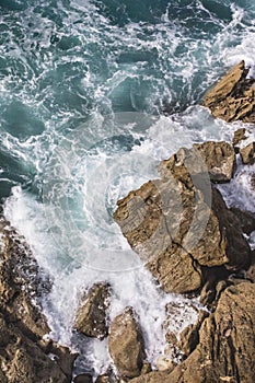 Foamy waves of the surf near the rocky shore