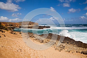 Foamy white ocean waves break down the rocky shore. Australian Beach with surf. Powerful pacific surf breaks down on the shore