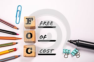 FOC - Free Of Cost. Text and stationery on a white background photo