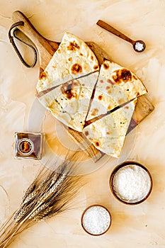 Focaccia ingredients. Wheat ears, flour, oil near bread on beige background top-down