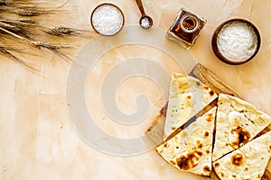 Focaccia ingredients. Wheat ears, flour, oil near bread on beige background top-down copy space