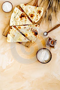 Focaccia ingredients. Wheat ears, flour, oil near bread on beige background top-down copy space