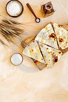 Focaccia ingredients. Wheat ears, flour, oil near bread on beige background top-down copy space