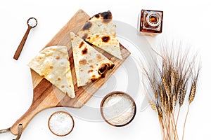 Focaccia ingredients. Wheat ears, flour, oil near bread on white background top-down