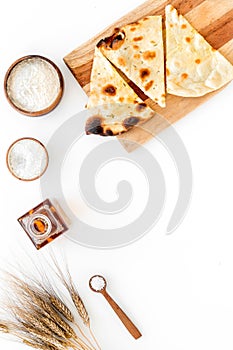 Focaccia ingredients. Wheat ears, flour, oil near bread on white background top-down copy space