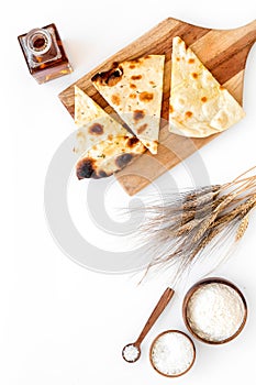 Focaccia ingredients. Wheat ears, flour, oil near bread on white background top-down copy space