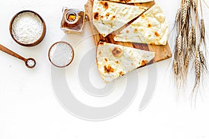 Focaccia ingredients. Wheat ears, flour, oil near bread on white background top-down copy space