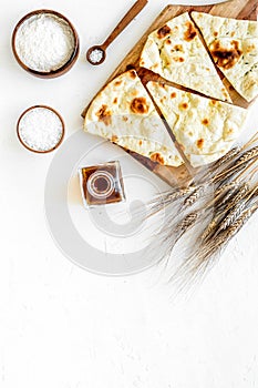 Focaccia ingredients. Wheat ears, flour, oil near bread on white background top-down copy space