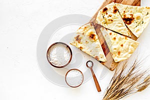 Focaccia ingredients. Wheat ears, flour, oil near bread on white background top-down copy space