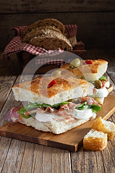 focaccia pizza with ham, mozzarella, salads and olives