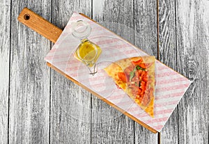 Foccacia with tomatoes and sauce on a cutting board on wooden background