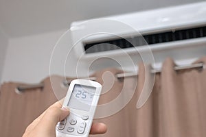 Focus ahead.Air condition control by using remote control and turn on the air conditioner at 25 degrees