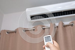 Focus ahead.Air condition control by using remote control and turn on the air conditioner at 25 degrees