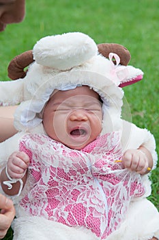 Focus at Asian newborn baby girl with costumes little sheep in the garden and mother is holding her.