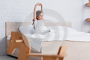 Focus of awakened kid stretching while