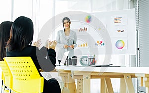 Focus beautiful Asian smiley businesswoman wearing suit, presenting business plan, coaching creative marketing idea in meeting,