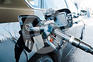 Focus of black modern automobile refueling with benzine on gas station
