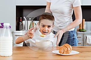 Focus of boy eating cereals near