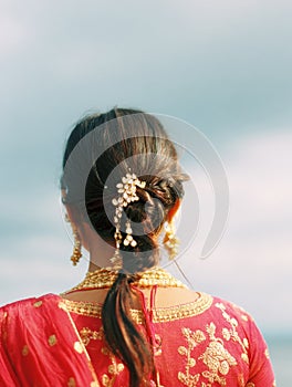 Bridal Hairstyle Adorned With Sindoor Under a Soft Sky Backdrop During a Wedding Preparation photo