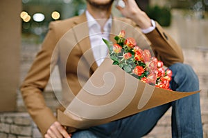 Focus on bunch of roses, folded in craft paper holded by man
