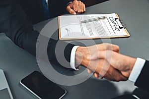 Focus business contract paper with blur background of handshake. Fervent