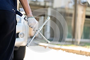 Focus car mechanic hand holding wrench for change the wheel on a broken car, uses tools or equipment, tries to solve problems by