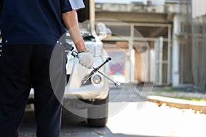 Focus car mechanic hand holding wrench for change the wheel on a broken car, uses tools or equipment, tries to solve problems by