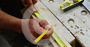 Focus on carpenter hands measuring wood