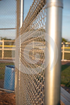 Focus on chain link fence with t-ball background photo