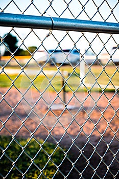 Focus on chain link fence with t-ball background photo