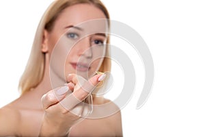 Focus on contact lens on finger of young woman. Young woman holding contact lens on finger in front of her face. Woman