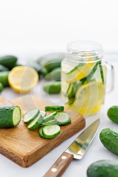 Focus on cucumber slices. Summer cocktail cucumber lemonade. Refreshing water with cucumber, mint and lemon on grey